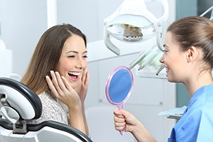 Woman admiring her new smile after cosmetic dentistry in West Lake Hills 