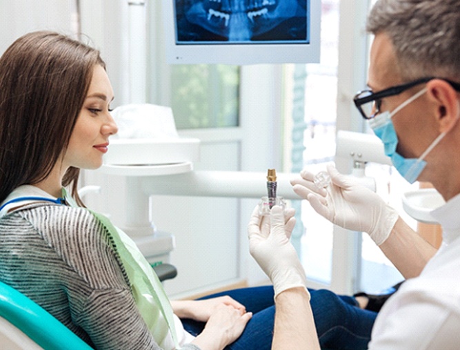 dentist showing a patient how dental implants work in Westlake