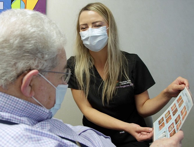 Dental team member and dental patient laughing together