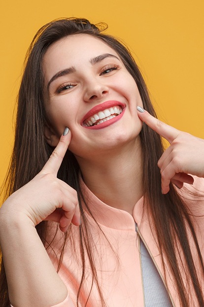 Smiling woman pointing to her teeth