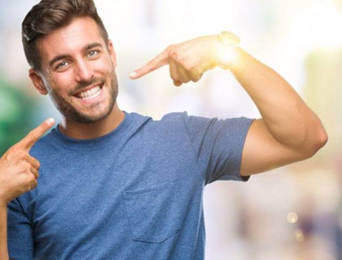 young man pointing to his smile 