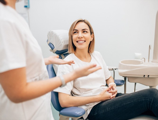 female dental patient talking to dentist 