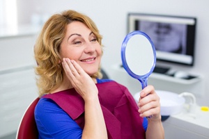 patient admiring her new smile with dental implants