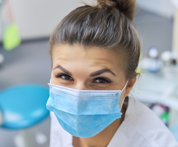 Smiling dental team member wearing a face mask