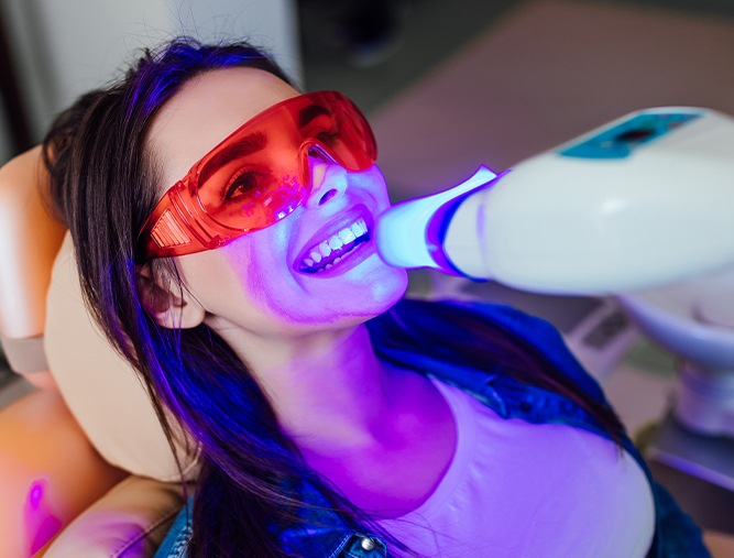 Woman receiving in office teeth whitening treatment