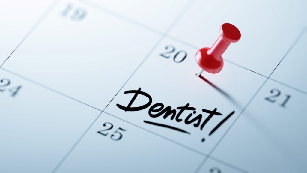 Dental appointment reminder on calendar with red pin
