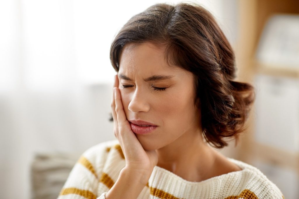 Woman experiencing mouth pain.