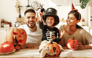 a family smiling and wearing Halloween costumes